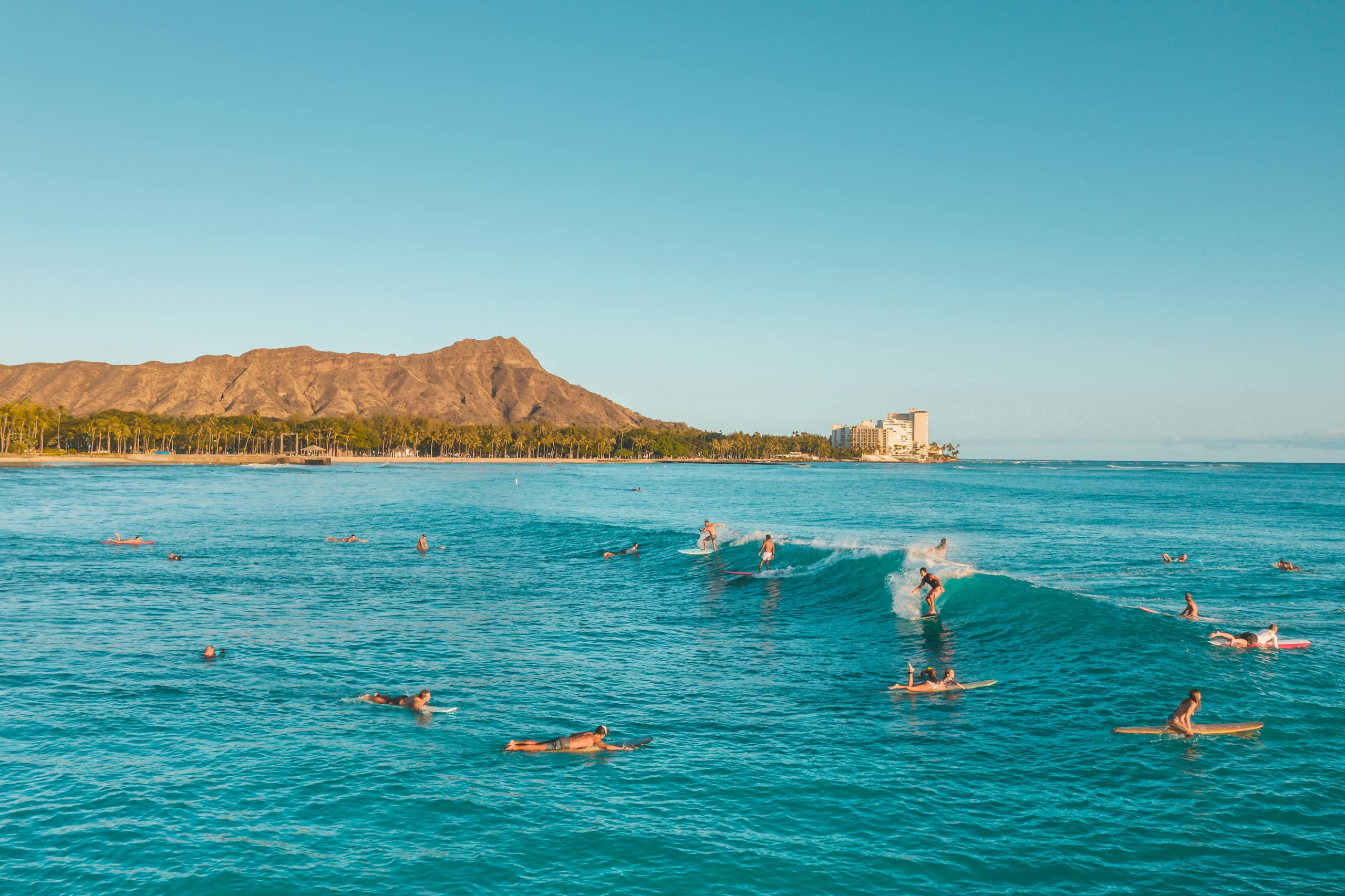 Scenic view of surfers at Waikiki Beach with Diamond Head in the background, Honolulu, Hawaii.